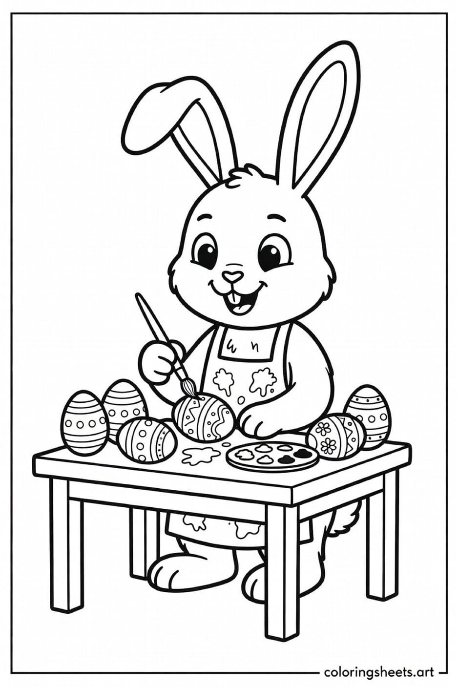 Easter bunny sitting at a table painting decorated eggs with a paintbrush and palette coloring page for kids — free printable PDF